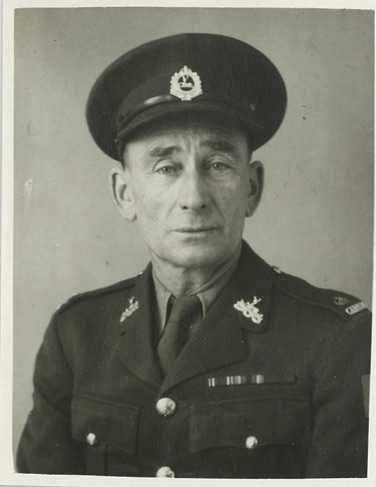 A black and white headshot of Archie in uniform taken around his enlistment in 1939. His face shows his age. Medals earned in the First World War are visible on his chest.